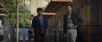 Movie still from “A Wrinkle in Time” (2018), directed by Ava DuVernay – A man and a woman standing next to each other in front of a chain link fence; Wide shot, Low angle