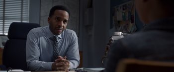 Movie still from “A Wrinkle in Time” (2018), directed by Ava DuVernay – A man sitting at a table with his hands crossed; Close Up shot, Over the shoulder angle