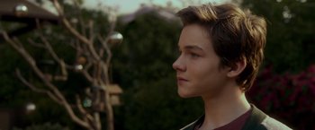 Movie still from “A Wrinkle in Time” (2018), directed by Ava DuVernay – A young man's face with trees in the background; Close Up shot, Over the shoulder angle