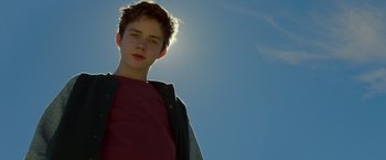 Movie still from “A Wrinkle in Time” (2018), directed by Ava DuVernay – A young boy standing in front of the sun; Close Up shot, Low angle