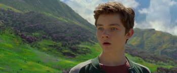 Movie still from “A Wrinkle in Time” (2018), directed by Ava DuVernay – A young boy is standing in front of a mountain; Close Up shot, Over the shoulder angle
