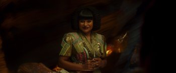 Movie still from “A Wrinkle in Time” (2018), directed by Ava DuVernay – A woman in a colorful dress with a black wig; Close Up shot, Over the shoulder angle