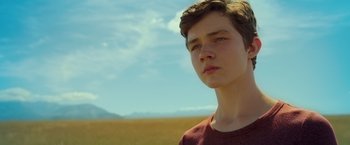 Movie still from “A Wrinkle in Time” (2018), directed by Ava DuVernay – A young man standing in the middle of an open field; Close Up shot, Low angle
