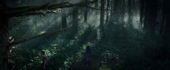 Movie still from “A Wrinkle in Time” (2018), directed by Ava DuVernay – A person standing in the middle of a lush green forest; Extreme Wide shot, High angle
