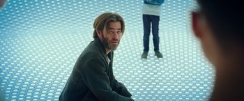 Movie still from “A Wrinkle in Time” (2018), directed by Ava DuVernay – A man sitting on the ground in front of another man; Medium shot, Low angle