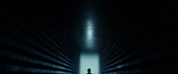 Movie still from “A Wrinkle in Time” (2018), directed by Ava DuVernay – A person standing in a dark room with a light shining on them; Extreme Wide shot, Low angle