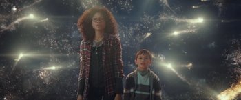 Movie still from “A Wrinkle in Time” (2018), directed by Ava DuVernay – Two people standing in front of a space background; Medium shot, Low angle