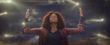 Movie still from “A Wrinkle in Time” (2018), directed by Ava DuVernay – A woman with her arms outstretched in front of the sun; Medium shot, Low angle
