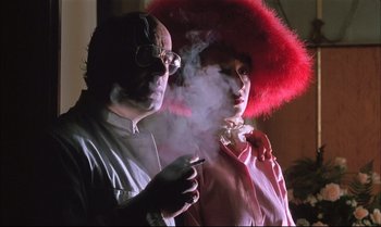 Movie still from “A Zed & Two Noughts” (1985), directed by Peter Greenaway – A man and a woman smoking a cigarette; Close Up shot, Low angle