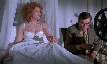 Movie still from “A Zed & Two Noughts” (1985), directed by Peter Greenaway – A man and a woman sitting on a bed; Medium shot, Low angle