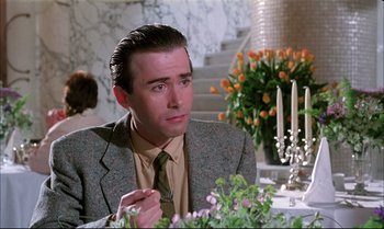Movie still from “A Zed & Two Noughts” (1985), directed by Peter Greenaway – A man sitting at a dinner table in front of flowers and candles; Close Up shot, Over the shoulder angle