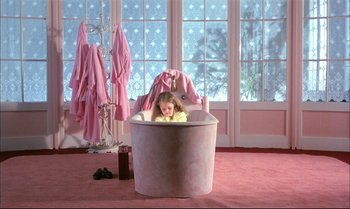 Movie still from “A Zed & Two Noughts” (1985), directed by Peter Greenaway – A little girl sitting in a tub in a pink room; Wide shot, High angle