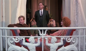 Movie still from “A Zed & Two Noughts” (1985), directed by Peter Greenaway – A group of people sitting on top of a bench; Wide shot, Low angle