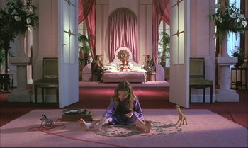 Movie still from “A Zed & Two Noughts” (1985), directed by Peter Greenaway – A girl sitting on the floor in front of a painting; Wide shot, High angle
