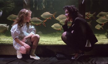 Movie still from “A Zed & Two Noughts” (1985), directed by Peter Greenaway – A woman and a girl looking at fish in an aquarium; Medium shot, High angle