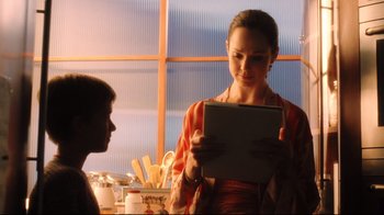 Movie still from “A.I. Artificial Intelligence” (2001), directed by Steven Spielberg – A woman holding an ipad in her hands; Close Up shot, Over the shoulder angle