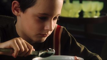 A young boy is eating a bowl of food