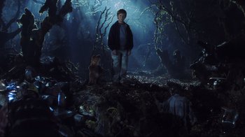 Movie still from “A.I. Artificial Intelligence” (2001), directed by Steven Spielberg – A boy standing in the middle of a forest with a teddy bear; Wide shot, Low angle