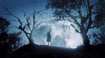 Movie still from “A.I. Artificial Intelligence” (2001), directed by Steven Spielberg – A man standing on top of a hill next to trees; Extreme Wide shot, Low angle