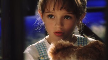 Movie still from “A.I. Artificial Intelligence” (2001), directed by Steven Spielberg – A little girl holding a teddy bear in her hands; Close Up shot, High angle