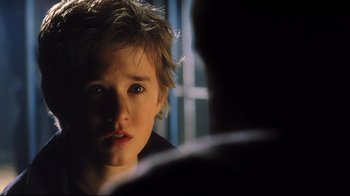 Movie still from “A.I. Artificial Intelligence” (2001), directed by Steven Spielberg – A young boy looking into a mirror in a dark room; Close Up shot, Over the shoulder angle
