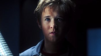 A young boy is looking into the camera