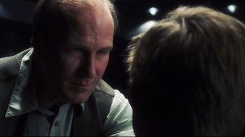 Movie still from “A.I. Artificial Intelligence” (2001), directed by Steven Spielberg – An older man talking to a younger man in front of a wall; Close Up shot, Over the shoulder angle