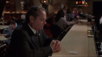 Movie still from “About Schmidt” (2002), directed by Alexander Payne – A man sitting at a table in front of other people at a restaurant; Medium shot, High angle