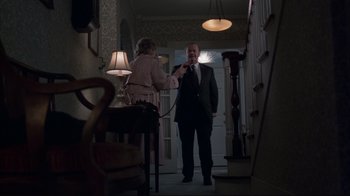 Movie still from “About Schmidt” (2002), directed by Alexander Payne – A man and a woman are standing in a hallway; Medium shot, High angle