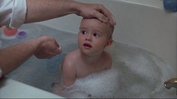 Movie still from “About Schmidt” (2002), directed by Alexander Payne – A baby being bathed in a bath tub by an adult; Close Up shot, High angle