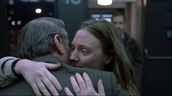 Movie still from “About Schmidt” (2002), directed by Alexander Payne – A man and a woman hugging each other in an airport; Close Up shot, Over the shoulder angle
