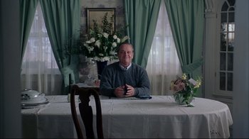 Movie still from “About Schmidt” (2002), directed by Alexander Payne – An older man sitting at a dining room table; Medium shot, High angle