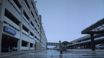 Movie still from “About Schmidt” (2002), directed by Alexander Payne – A man standing in front of a parking garage; Extreme Wide shot, Low angle