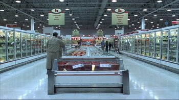Movie still from “About Schmidt” (2002), directed by Alexander Payne – A man standing in front of a display case in a grocery store; Extreme Wide shot, High angle