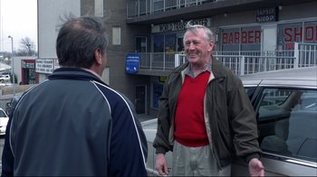 Two older men standing in front of a tall building