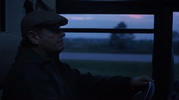 Movie still from “About Schmidt” (2002), directed by Alexander Payne – A man sitting in a car looking out the window at dusk; Close Up shot, Low angle