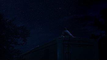 Movie still from “About Schmidt” (2002), directed by Alexander Payne – A person standing on top of a building at night; Extreme Wide shot, Low angle