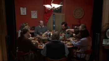 Movie still from “About Schmidt” (2002), directed by Alexander Payne – A group of people sitting around a table eating food; Wide shot, High angle
