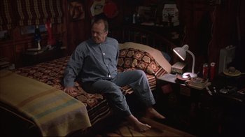 Movie still from “About Schmidt” (2002), directed by Alexander Payne – A man sitting on a bed in a room; Wide shot, High angle