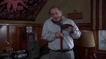 Movie still from “About Schmidt” (2002), directed by Alexander Payne – An older man holding a tie in a room; Medium shot, Low angle
