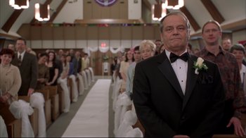 Movie still from “About Schmidt” (2002), directed by Alexander Payne – A man in a tuxedo standing in front of a group of people; Medium shot, Low angle