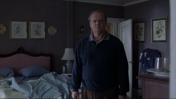 Movie still from “About Schmidt” (2002), directed by Alexander Payne – An older man standing in front of a bed in a bedroom; Medium shot, Over the shoulder angle