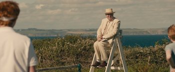 Movie still from “About Time” (2013), directed by Richard Curtis – An older man sitting on top of a ladder in a field; Wide shot, Low angle