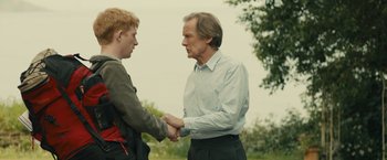 Movie still from “About Time” (2013), directed by Richard Curtis – Two people shaking hands in a field; Medium shot, Over the shoulder angle