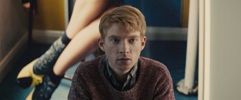 Movie still from “About Time” (2013), directed by Richard Curtis – A young man with blonde hair wearing a red sweater; Close Up shot, Low angle