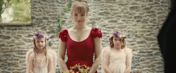 Movie still from “About Time” (2013), directed by Richard Curtis – A woman in a red dress holding a bouquet of flowers; Medium shot, Over the shoulder angle