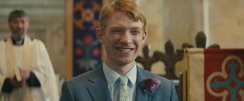Movie still from “About Time” (2013), directed by Richard Curtis – A man in a suit and tie smiling for the camera; Close Up shot, Over the shoulder angle