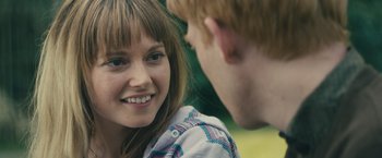 Movie still from “About Time” (2013), directed by Richard Curtis – A young woman smiles at a young man; Close Up shot, Over the shoulder angle