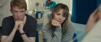 Movie still from “About Time” (2013), directed by Richard Curtis – A woman sitting in front of a man in a hospital room; Close Up shot, Over the shoulder angle