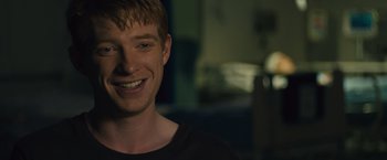 Movie still from “About Time” (2013), directed by Richard Curtis – A young man smiling for the camera in the dark; Close Up shot, Over the shoulder angle